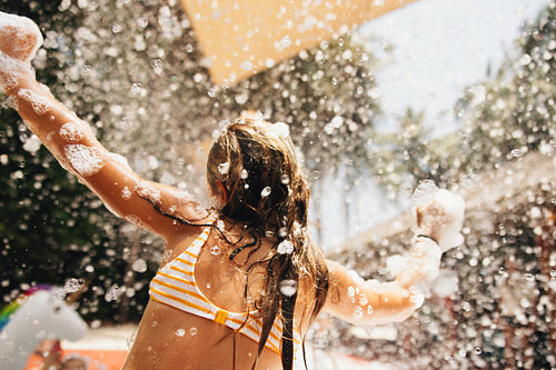 Child enjoying a foam party at a resort kids club outdoors on a sunny day