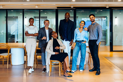 Group of diverse professional colleagues standing together in an open office space