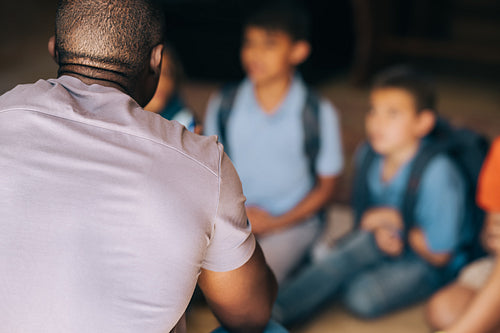 School mentor talking to a group of children in elementary school