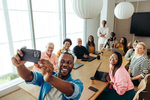 Diverse group taking a photo together in a vibrant office setting