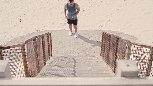 Fit young man exercising on the steps at the beach
