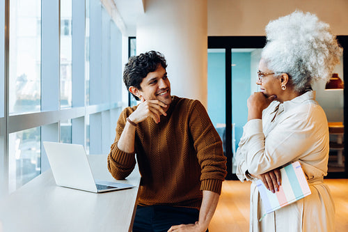 Two colleagues discuss ideas at the office