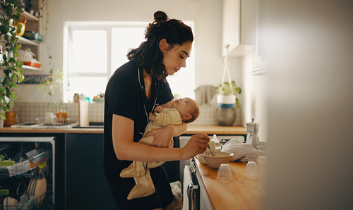 Mother caring for baby in kitchen