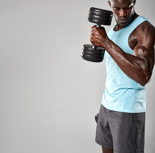 Young african man working out with dumbbells 