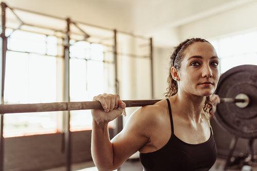 Young female doing squats at gym