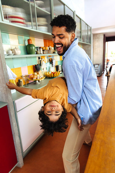Joyful father and son playing together in a modern kitchen setting