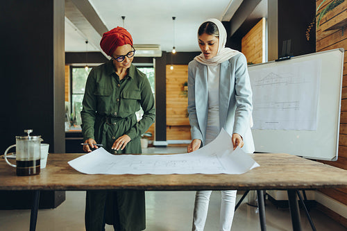 Innovative Muslim architects working on blueprint drawings