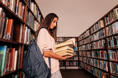 Young student reading books in library