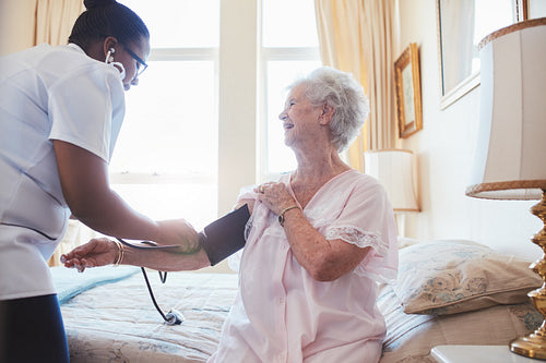 Nurse checking blood pressure of a senior woman