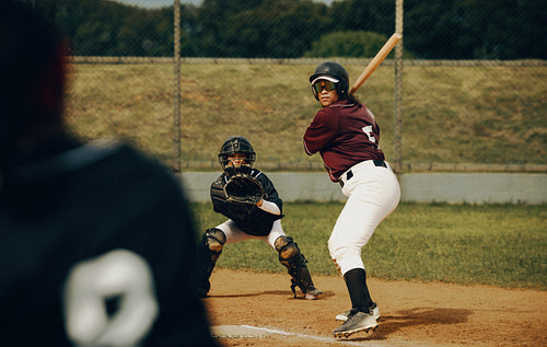 Baseball game action featuring a focused pitcher, ready batter, and attentive catcher