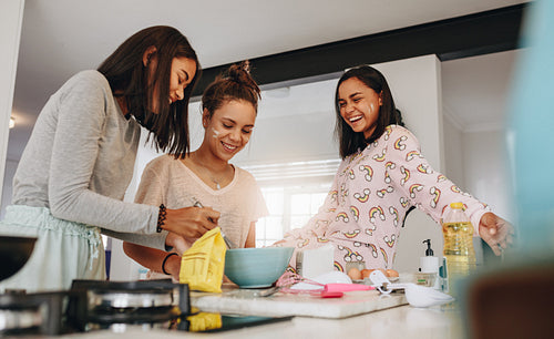 Girls having fun cooking together at home