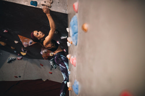 Woman climbing indoor boulder wall