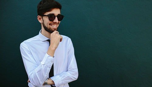Businessman in sunglasses looking away and smiling