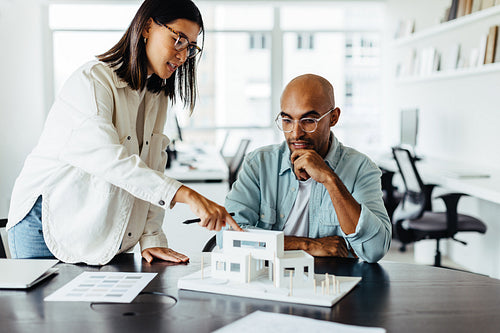 Business woman discussing an architectural model with her colleague