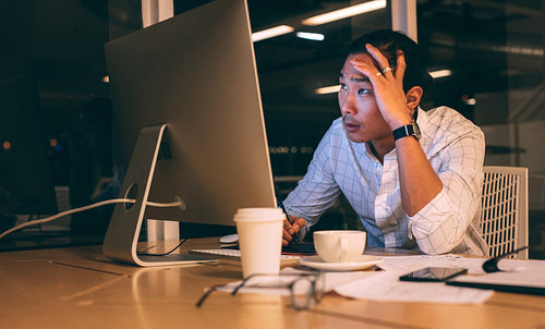 Businessman working late night in office looking stressed