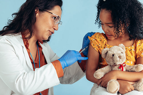 Doctor giving flu shot to a girl