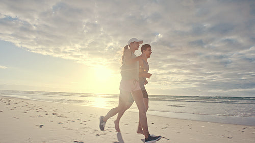 Young people running on beach in morning