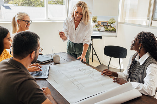Team of architects discussing building plans during a collaborative meeting in the office