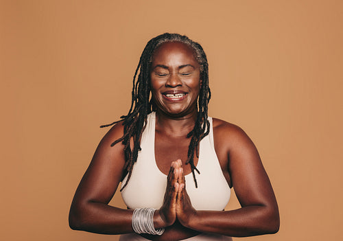 Happy black woman meditating in a studio