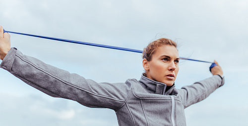 Young and fit woman exercising with resistance band