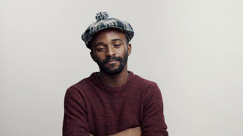 Man smiling in a cardigan and cap