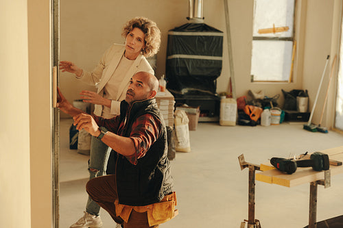Architect working with a construction worker working for her home renovation project