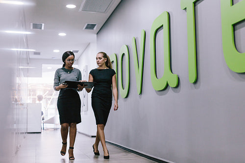 Business professionals discussing work in office hallway