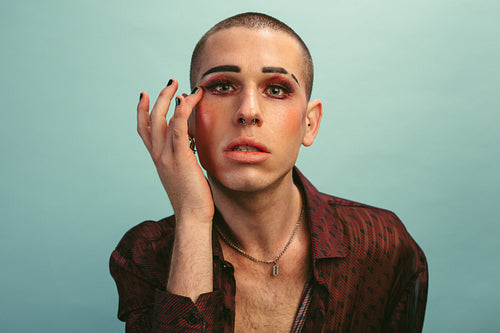 Gender fluid male fixing his makeup