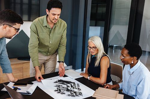 Team discussing architectural designs in a modern office space