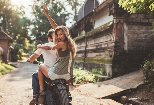 Couple enjoying motorcycle ride on village road