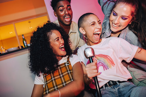 Excited friends enjoying karaoke