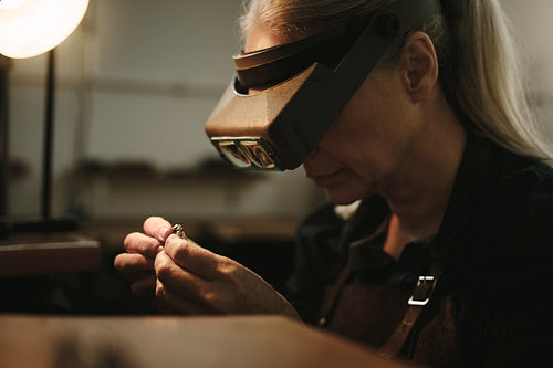 Senior jeweler examining a ring with magnifying glass