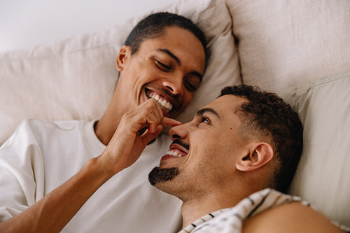 Happy couple enjoys a playful moment together at home on the couch