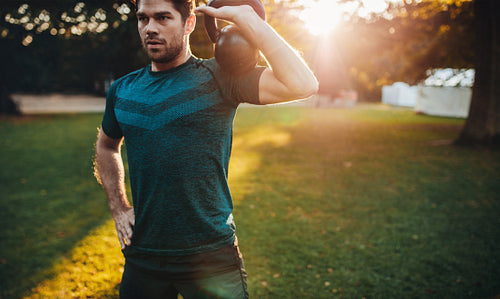 Healthy young man working out with kettlebell