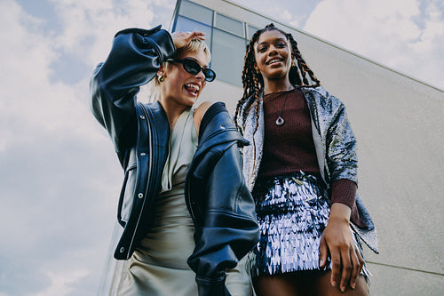 Two women pose together outdoors in the city