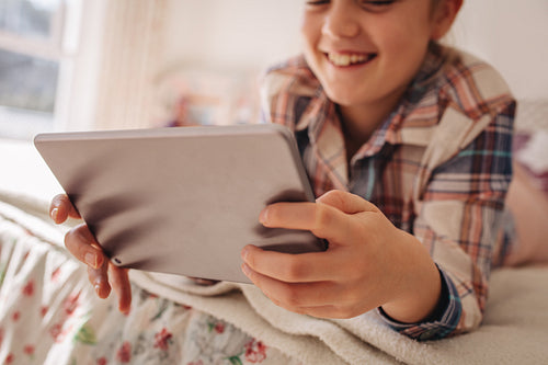 Girl using digital tablet in bed