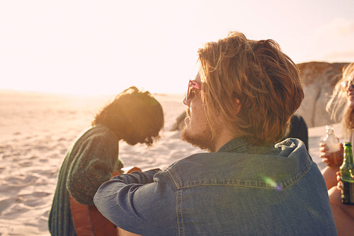 Young man enjoying at the beach with group of friend