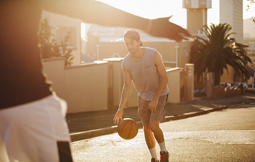 Men playing basketball on street