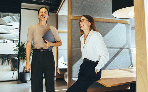 Female business professionals laughing in an office
