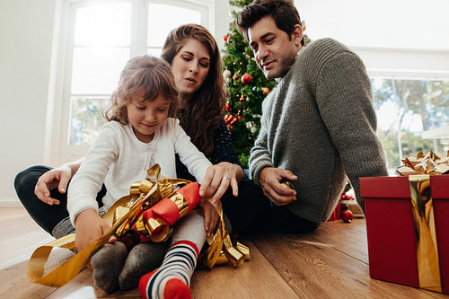 Little girl opening her Christmas gifts.