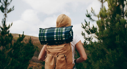 Rear view of a explorer woman carrying travelling kit