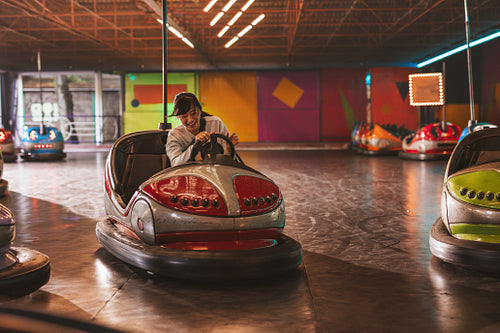 Smiling young woman driving a bumper car
