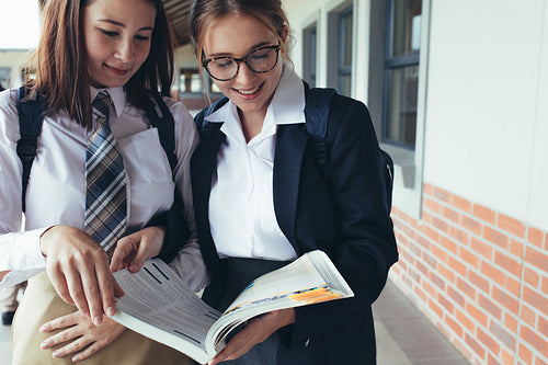 Two female high school students in corridor