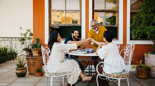 Family gathering enjoying an outdoor meal with laughter and conversation