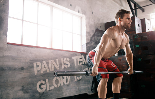 Bodybuilder cross training with barbell