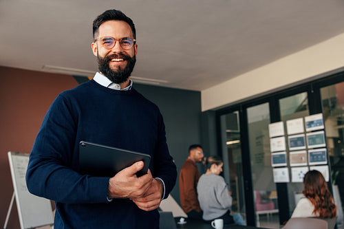 Successful businessman smiling at the camera in a boardroom