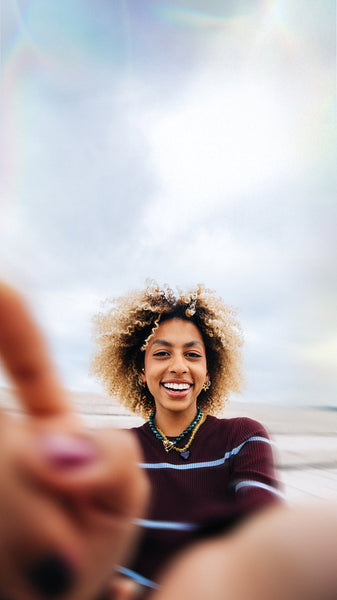 Smiling woman taking a selfie at the beach