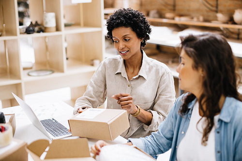 Two online store owners preparing some orders for shipping