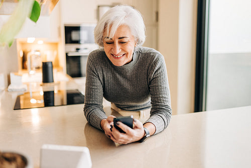 Elderly woman speaking to a smart device in her home