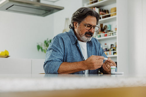 Diabetes monitoring helps a senior man test at home